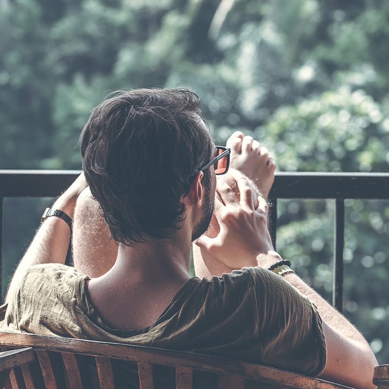 man relaxing on back porch