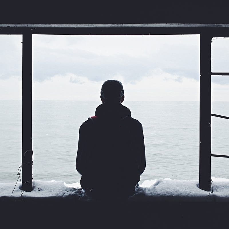 man sitting on snowy bank