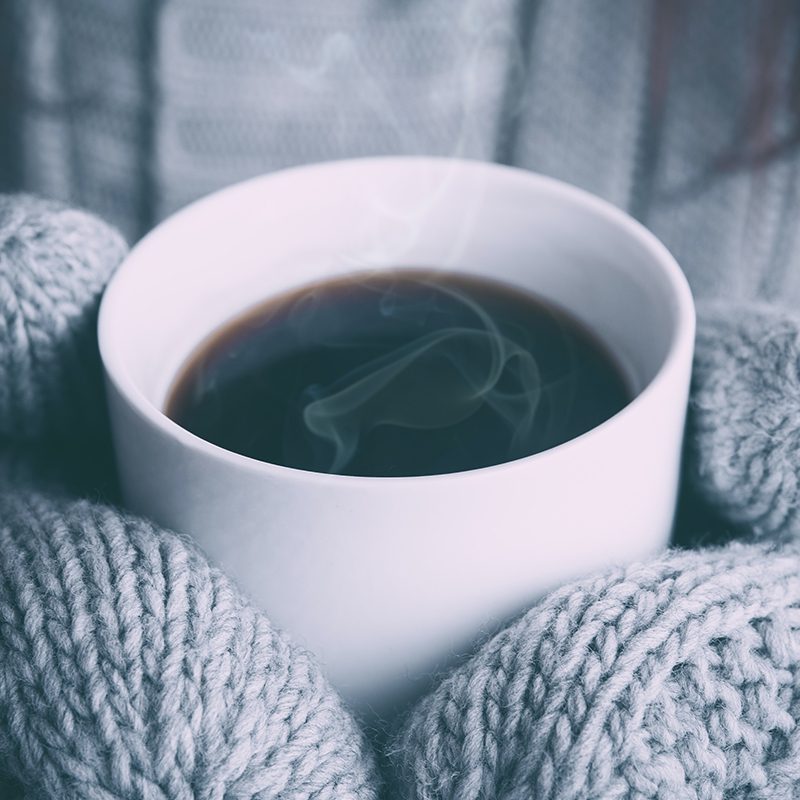 warm cup of coffee and fuzzy mittens